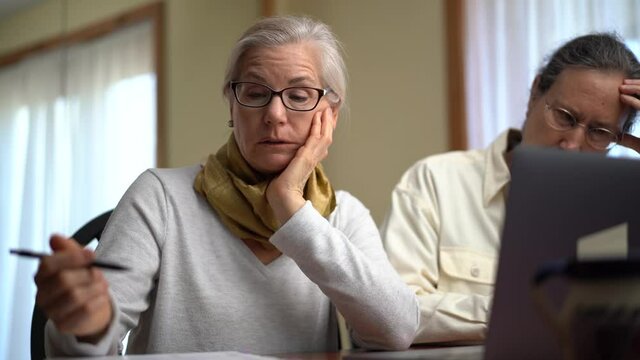 Tired, Mature Couple At Home Working On Laptop Computer. Concept Of Man And Woman Remote Working Together.