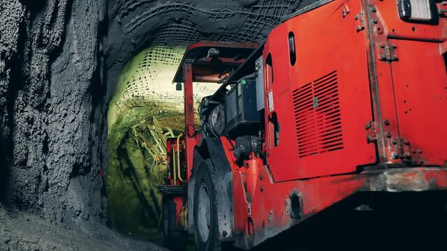 Massive boring machine working in the underground mine. Underground development, underground extraction, underground mining operations.