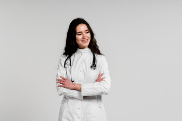 Girl surgeon in medical dress with curly hair on white background. 3rd wave of coronavirus covid-19 epidemy.