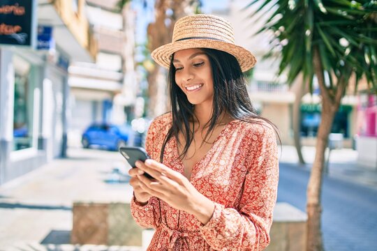 Young african american tourist woman on vacation smiling happy using smartphone at the city.