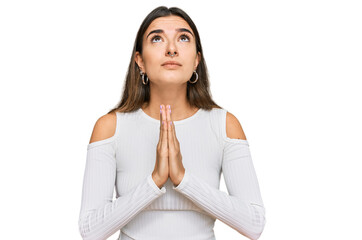 Young hispanic woman wearing casual clothes begging and praying with hands together with hope expression on face very emotional and worried. begging.