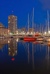 Fototapeta na wymiar Oostende (Ostend) yacht marina harbor at night in vertical format, Belgium.