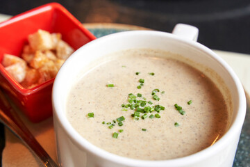 Creamy onion soup with green. Health food at cafe. Classic cuisine. Cooking bowl with bread croutons. Yam dish. Hot vegetable plate