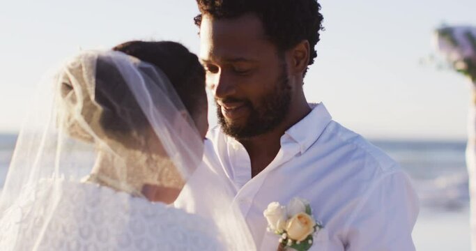 African american couple in love getting married, looking at each other on the beach