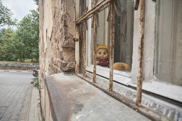 Doll looks out of the window. Her eyes are wide open and she wears a cap and jacket. Who is playing...