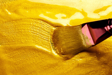 Beautiful abstract golden liquid paint background with brush, beauty gold backdrop texture....