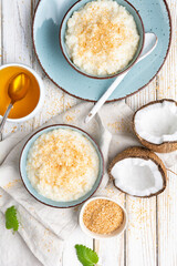 Sweet and creamy coconut rice pudding with honey, topped with grated and toasted coconut