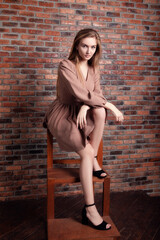 beautiful model girl in red on a brick wall background