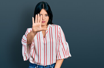 Young hispanic girl wearing casual clothes doing stop sing with palm of the hand. warning...