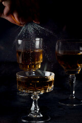 Clear crystal glass filled with golden liquor on dark background.