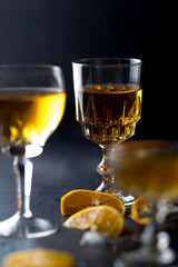 Clear crystal glass filled with golden liquor on dark background.