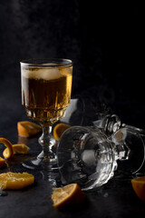 Clear crystal glass filled with golden liquor on dark background.