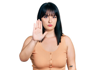 Young hispanic plus size woman wearing casual clothes doing stop sing with palm of the hand....