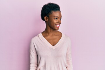 Young african american girl wearing casual clothes looking to side, relax profile pose with natural face and confident smile.