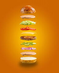Floating ham burger ingredients on the yellow background