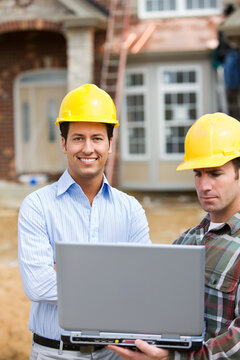 Construction: Architect Checks Laptop with Contractor