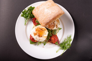 Serving poached eggs in a sandwich. White square sandwich bread and poached eggs. View from above.