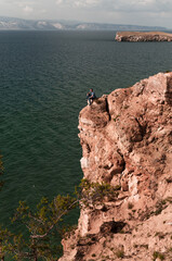 Man on the edge on a high rock on Lake Baikal