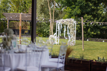 Wedding ceremony with arch,flowers and white macrame in rustic style. Wedding decoration with chair
