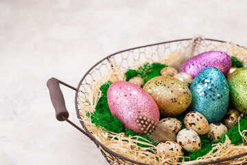Easter background. Easter composition with colorful Easter eggs on moss in basket. Happy Easter card for spring holiday