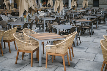 Closed coffee shop's and restaurants in city center due to corona virus, covid19 crisis lockdown. Empty chairs and tables during day. Deserted city.