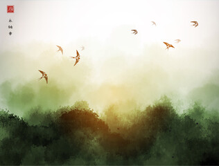 Landscape with green misty forest mountains and flock of swallow birds in the sky. Traditional oriental ink painting sumi-e, u-sin, go-hua. Hieroglyphs - eternity, freedom, happiness, joy