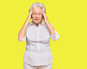 Senior grey-haired woman wearing casual clothes with hand on head for pain in head because stress. suffering migraine.