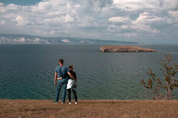 Man and woman on the shore of a large lake