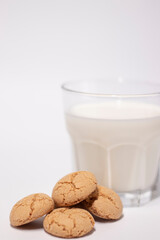 glass of milk near almond amaretti cookies isolated on white background. healthy breakfast snack