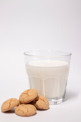 glass of milk near almond amaretti cookies isolated on white background. healthy breakfast snack