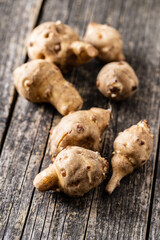 Raw jerusalem artichoke. Topinambur vegetable root on wooden table.