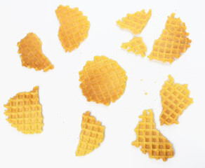 baked round belgian waffles on white background, broken pieces and crumbs