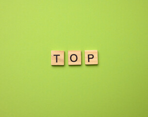 inscription top from wooden cubes on a green background