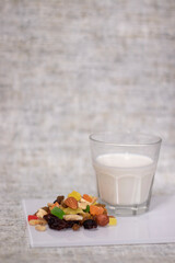 glass of milk near dried fruits, candied fruits, raisins, nuts. healthy breakfast snack