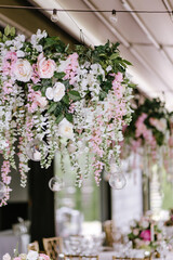 Fototapeta premium Close up of pink flower composition for wedding decoration. Decoration for wedding using candles and different nature flowers and leafs
