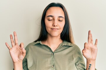 Young hispanic woman wearing casual clothes relax and smiling with eyes closed doing meditation gesture with fingers. yoga concept.