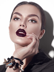 Beauty Fashion model girl with dark lips portrait, wearing stylish sexy woman portrait with perfect makeup, trendy accessories and fashion wear. Beauty trends. Perfect skin. White background