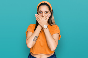 Fototapeta premium Young hispanic woman wearing casual clothes shocked covering mouth with hands for mistake. secret concept.
