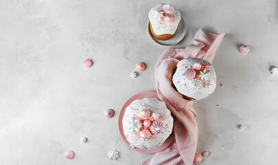 Traditional Russian Rustic Easter Kulich Cakes with Marshmallow, Sweet Filling, with Icing and confectionery sprinkles as Decoration on white background with copy space.