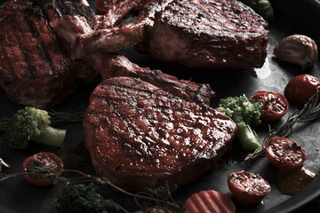 Piece of appetizing pork steak on the bone with vegetables in vintage style.