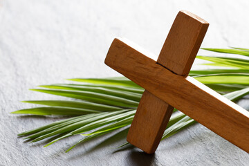 Wooden cross and palm on marble background, palm sunday concept