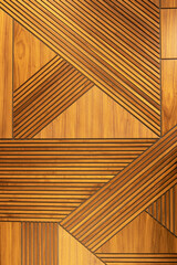 Designer walnut veneer panel, geometric crisscross pattern wood wall. Architectural background, texture. The concept is a modern interior, natural materials, minimalism style. Vertical