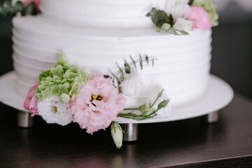 White wedding cake decorated with eucalyptus and natural flowers. Celebrating and floristics concept