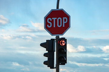 German stop sign and a traffic light showing red, arrow to the left