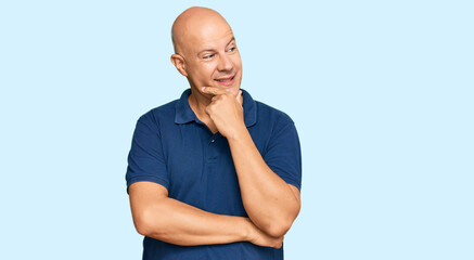 Fototapeta premium Middle age bald man wearing casual clothes with hand on chin thinking about question, pensive expression. smiling with thoughtful face. doubt concept.