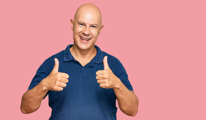 Middle age bald man wearing casual clothes success sign doing positive gesture with hand, thumbs up...
