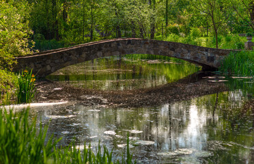 Fototapeta na wymiar An old bridge on the lake. Radomyshl, Ukraine.
