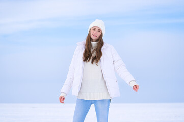 Beautiful smiling young woman in wintertime outdoor, ice. Winter concept, white
