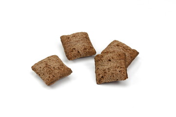 Heap of chocolate pillow cereals isolated on white background. Nougat filled chocolate pillow wafers pile isolated on white background. Crispy chocolate cereal pillow flakes.