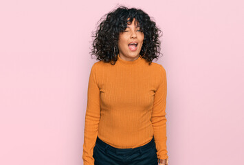 Young hispanic woman wearing casual clothes winking looking at the camera with sexy expression,...